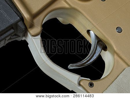 Brown Colored Ar-15 Trigger With A Black Background