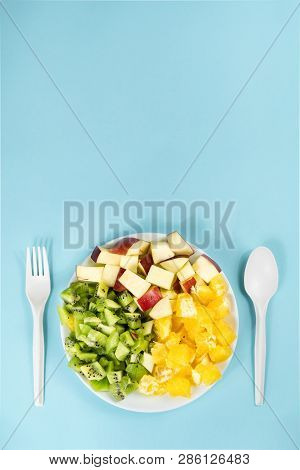Plant Based Food Diet Concept. Top View Of Fresh Fruit On A Plate In Pale Blue Background With Copy 