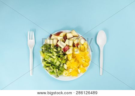 Plant Based Food Diet Concept. Top View Of Fresh Fruit On A Plate In Pale Blue Background With Copy 