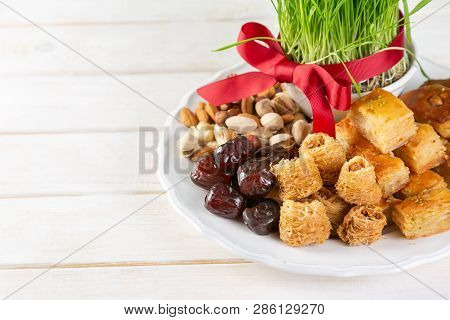 Nowruz Holiday Concept - Grass, Baklava Sweets, Nuts And Seeds, Copy Space