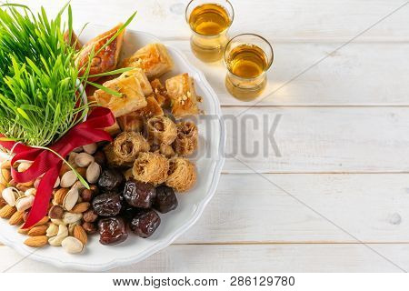 Nowruz Holiday Concept - Grass, Baklava Sweets, Nuts And Seeds, Copy Space