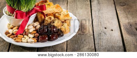Nowruz Holiday Concept - Grass, Baklava Sweets, Nuts And Seeds, Copy Space
