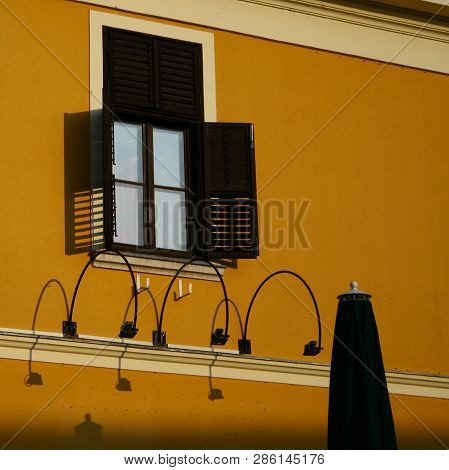 The Reflecting Wndow With Orange Wall And With Brown Shutter