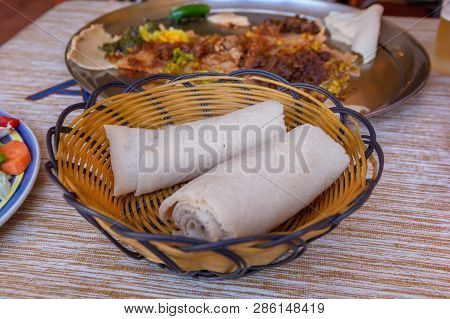 Rolls Of Injera In A Serving Bowl.  Injera Is A Sourdough Flatbread Made From Teff Flour.  It Is The