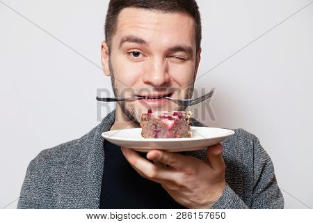 Closeup Portrait Young Cute Caucasian Man Smile, Hold Fork In His Teeth And White Round Plate With P