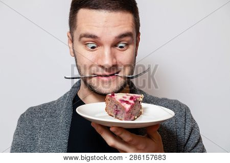 Closeup Portrait Young Cute Caucasian Man Smile, Hold Fork In His Teeth And White Round Plate With P