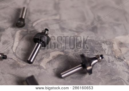 Scattered Set Of Steel Router Bit For Milling Cutter On Old Broken Worn Gray Concrete Floor With Cop