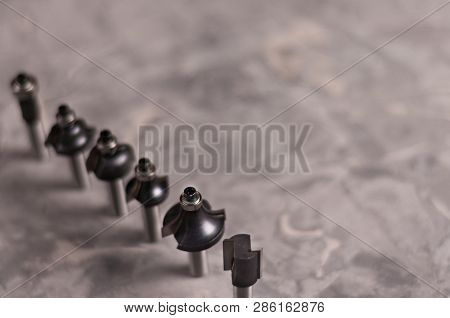Row Of Lot Of Steel Router Bits For Milling Cutter On Old Broken Worn Gray Concrete Floor With Copy 