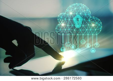 Side View Of Backlit Hand Using Tablet With Digital Polygonal Cloud On Blurry Background. Cloud Comp