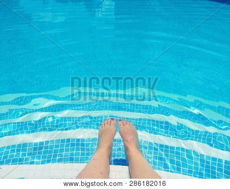 A Woman With Her Legs In The Pool