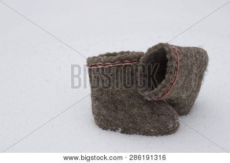 A Pair Of Russian Felt Boots Standing On White Snow In Winter Close-up