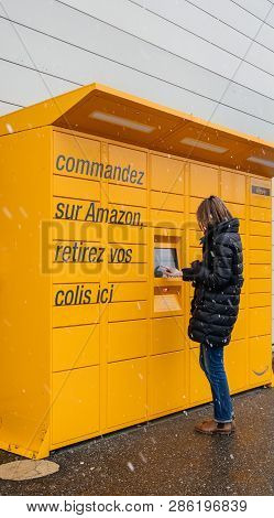 Strasbourg, France - Feb 8, 2018: Side View Of Young French Woman Using Amazon Locker The Self-servi