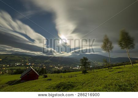 Summer Night Mountain Panorama. Small House Cottage On Steep Mountain Slope On Dramatic Evening Sky 