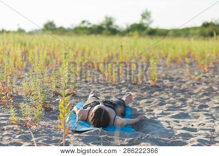 Young Woman Performing Yoga Nidra On Sand