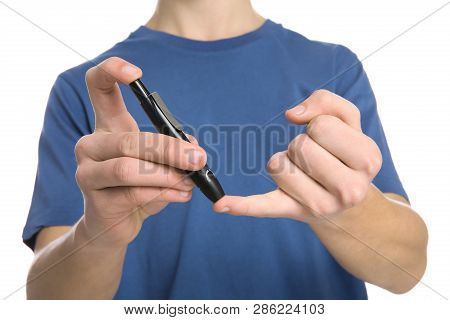 Teen Boy Using Lancet Pen On White Background, Closeup. Diabetes Control