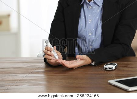 Young African-american Woman Using Lancet Pen At Workplace, Closeup. Diabetes Control