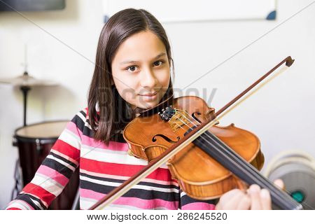 Little Skillful Student Getting Violin Training As A Part Of Extracurricular Activities In School