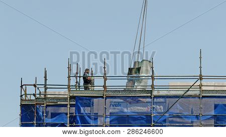 Gosford, New South Wales, Australia - November 30, 2018: Crane Operator In Control Of Equipment Deli