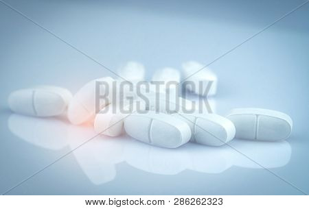 Pile Of White Oblong Tablets Pills On Gradient Background. Pharmaceutical Industry. Pharmacy Product