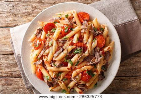 Italian Penne Pasta With Pulled Pork, Cheese, Tomato Sauce And Herbs Close-up On A Plate. Horizontal