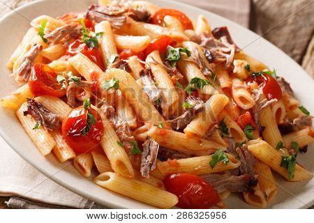 Serving Penne Pasta With Pulled Pork, Cheese, Tomato Sauce And Herbs Close-up On A Plate. Horizontal