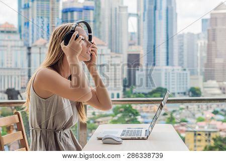 Young Woman Teaches A Foreign Language Or Learns A Foreign Language On The Internet On Her Balcony A