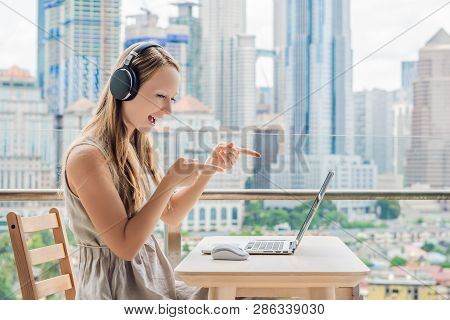 Young Woman Teaches A Foreign Language Or Learns A Foreign Language On The Internet On Her Balcony A