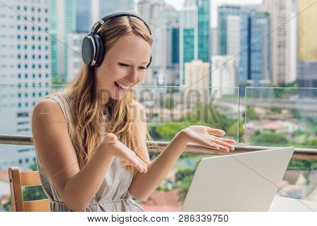 Young Woman Teaches A Foreign Language Or Learns A Foreign Language On The Internet On Her Balcony A