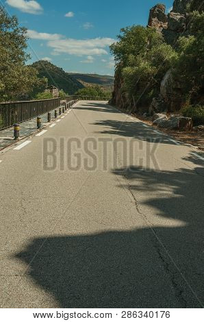 Road Through Rocky Cliffs Covered By Trees