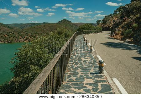 Road Through Rocky Cliffs Covered By Trees