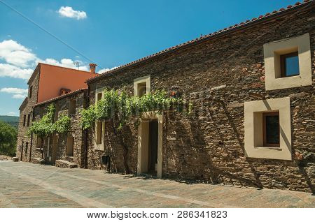 Street With Rustic Houses And Stone Walls With Plants, In A Sunny Day At The Monfrague National Park
