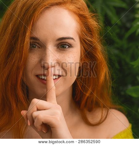 Shh, Its Our Secret. Friendly Redhead Woman Put Finger On Lips, Showing Silence Sign, Close Up Portr