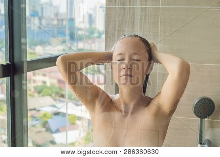 Beautiful Woman In The Shower Behind Glass With Drops On The Background Of A Window With A Panoramic