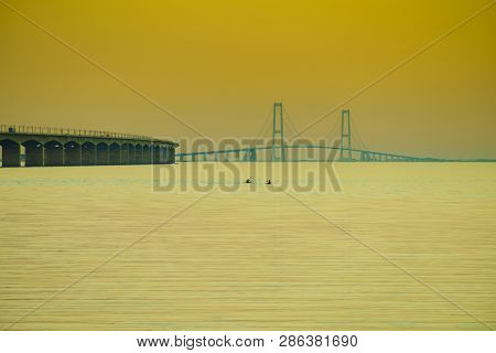 The Bridge Across The Great Belt - The Storebaelt Bridge In Denmark. Two Canoes On Water Surface. Su