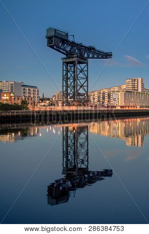 Glasgow/scotland - September 20 2016: The Finnieston Crane Against A Blue Sky, With A Mirror Image R