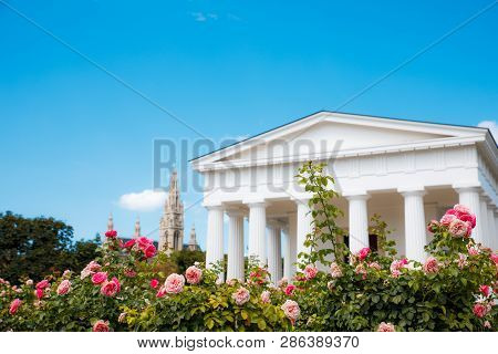 Vienna, Austria - Tourists Visiting The Theseus Temple In Volksgarten Park With The City Hall At The