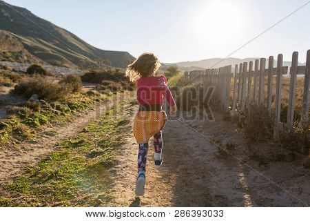 Little girl running through the Spanish landscape, Rambla del Playazo, Cabo de Gata - Nijar Natural Park, Spain