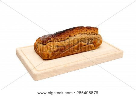 A Homemade Plumcake Standing On A Wooden Board With A White Background