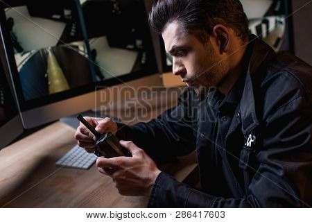 Concentarted Guard In Uniform Holding Walkie-talkie At Workplace