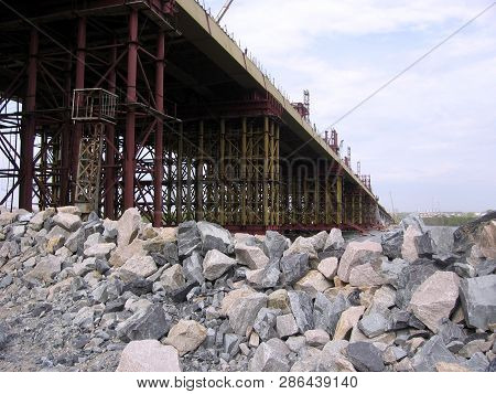 Construction Bugrinskij Bridge In Novosibirsk On The River Ob A Pile Of Large Stones For Building Co