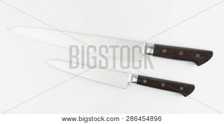 Pair of new chef knives shot on light gray surface