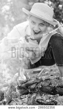 Woman In Straw Hat Try To Bite Sausage On Stick. Girl Eats Sausage On Stick. She Has Strong Appetite