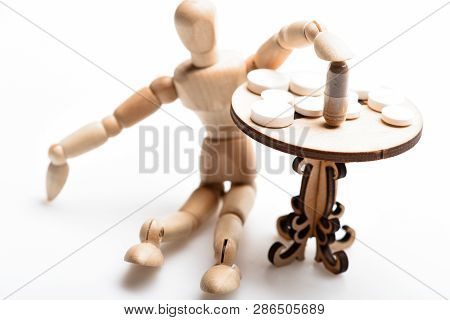 Pills On Tiny Wooden Table. Medication Regimen. Human Wooden Dummy Near Table With Medicines. Tips T