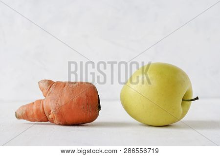 Misshapen Ugly Fresh Golden Apple And Carrot With Appendages On White Viewed Low Angle Close Up