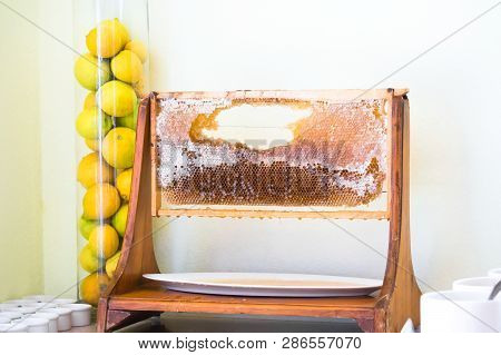 Wooden Honeycomb Display Frame In Restaurant And Lemons Aside In Glass Tube Vase.