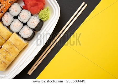 Top View On Sushi Set At Colored Background. Plate With Rolls, Ginger And Vasabi