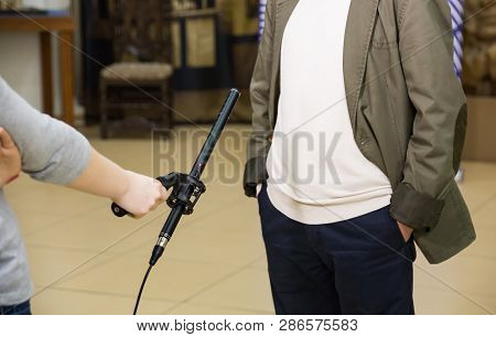 Condenser Shotgun Microphone. A Woman Interviews A Man. The Microphone In The Reporters Hand.