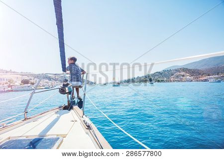 Little Boy On Board Of Sailing Yacht On Summer Cruise. Travel Adventure, Yachting With Child On Fami