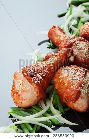 Roasted Chicken Legs On The Miror Background. On The Green Onion.copy Space