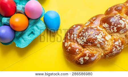 Easter Eggs And Tsoureki Braid, Greek Easter Sweet Bread, On Yellow Color Background